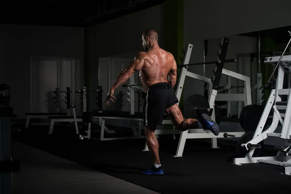 肌肉发达的男人在健身房里柔韧肌肉 — 图库照片