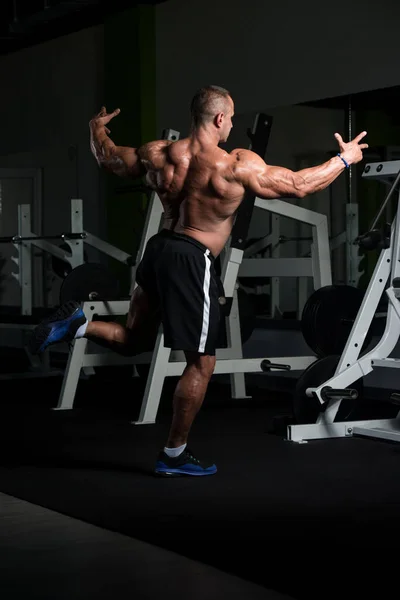 Volwassen gespierde man Flexende spieren in de sportschool — Stockfoto