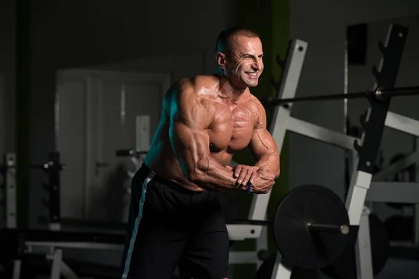 Reifer Bodybuilder posiert nach Übungen mit Bizeps — Stockfoto