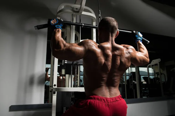 Culturista haciendo ejercicio de vuelta en el gimnasio —  Fotos de Stock