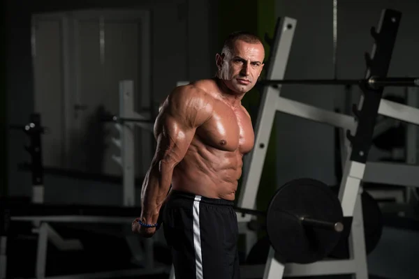 Reifer Bodybuilder lässt Muskeln spielen — Stockfoto