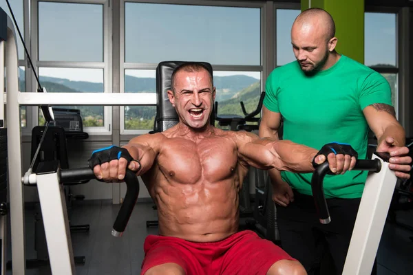 Fitnesscoach hilft Mann auf der Brust — Stockfoto