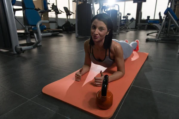 Ung kvinna gör buken övning i gymmet — Stockfoto