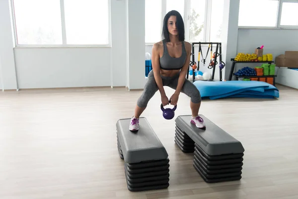 Jeune femme en bonne santé faisant l'exercice avec la cloche de bouilloire — Photo