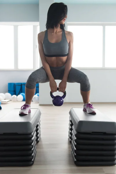 Kvinnan gör tung vikt träning med vattenkokare-bell — Stockfoto