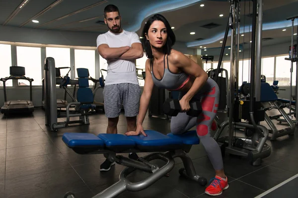 Paar mit Kurzhanteln trainiert Rücken im Fitnessstudio — Stockfoto