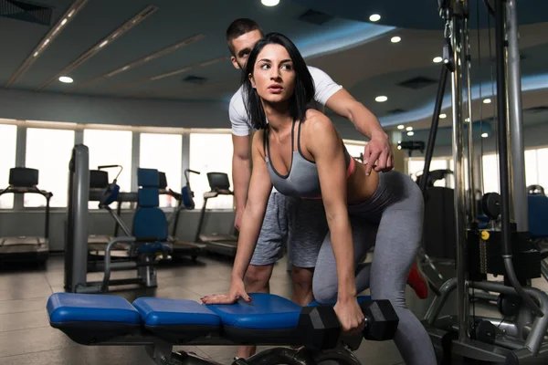 Pareja con sombrillas haciendo ejercicio de vuelta en el gimnasio —  Fotos de Stock