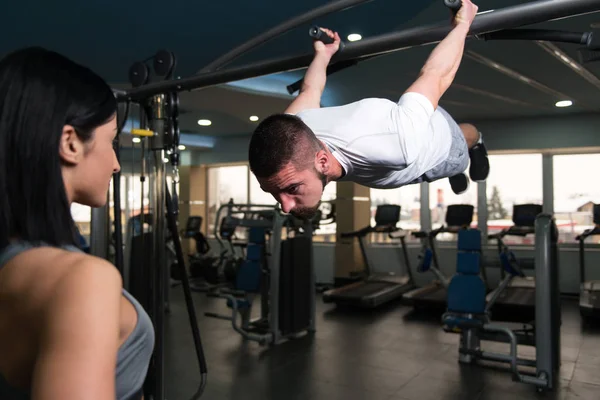 Uomo che fa esercizi di pull-up con allenatore di palestra — Foto Stock