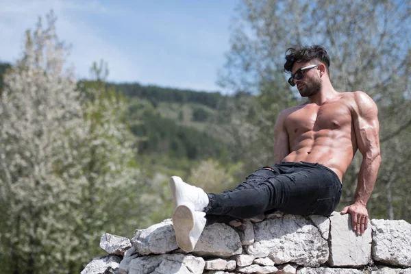 Model Flexing Muscles Outdoors in Nature — Stock Photo, Image