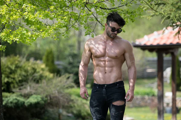 Model Flexing Muscles Outdoors in Nature — Stock Photo, Image