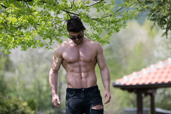 Modelo muscular serio de pie al aire libre en la naturaleza —  Fotos de Stock