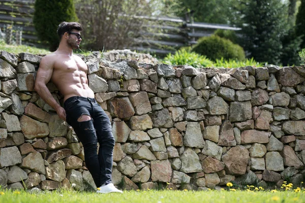 Model Flexing Muscles Outdoors in Nature — Stock Photo, Image