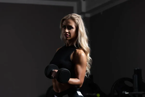 Jovem mulher fazendo bíceps exercício com halteres — Fotografia de Stock