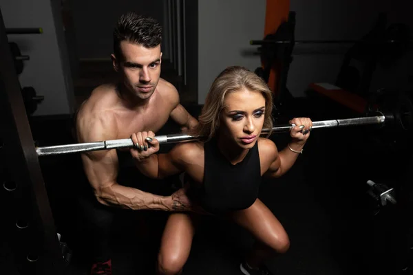 Mulher com o Personal Trainer em Barbell Squat — Fotografia de Stock