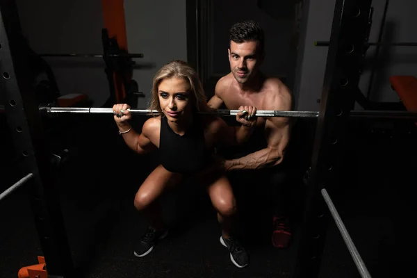 Donna con personal trainer a bilanciere squat — Foto Stock