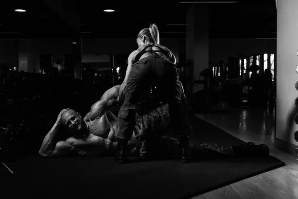 Fit Woman podnoszenie partnera z podłogi — Zdjęcie stockowe