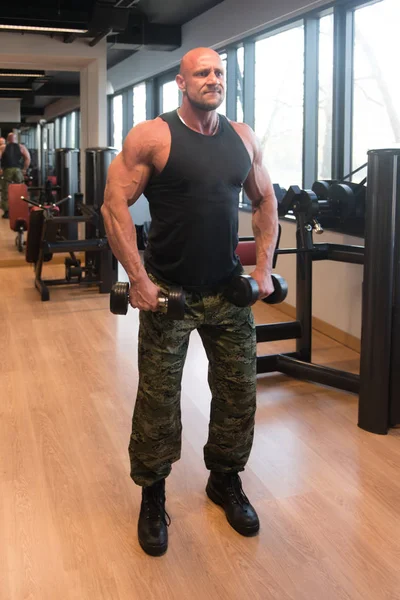 Exercice des épaules avec haltères dans une salle de gym — Photo