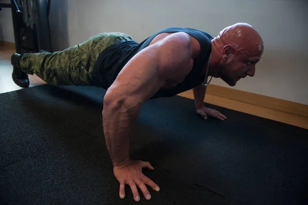 Modèle faisant des soulèvements de presse dans le gymnase — Photo