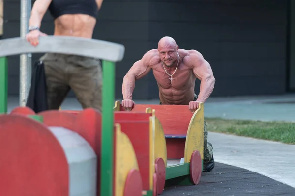 Bodybuilding-Paar spielt im Freien nach dem Sport in der Turnhalle — Stockfoto