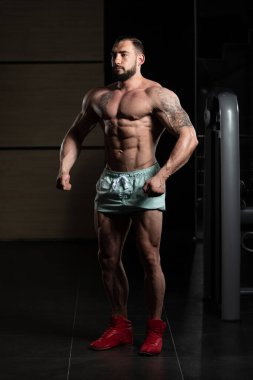 Yakışıklı kaslı adam içinde jimnastik salonu kas esneme