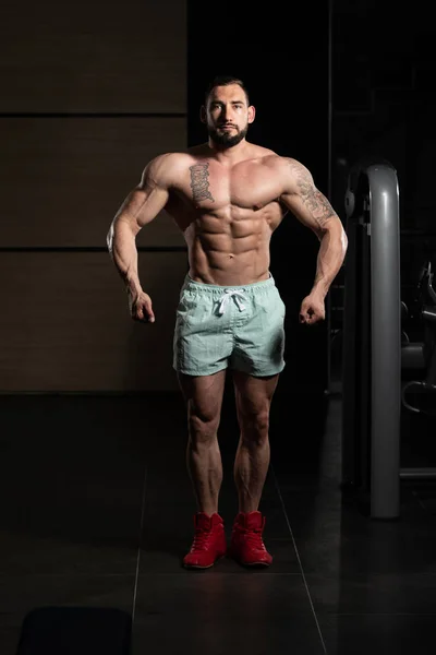 Hombre joven saludable Flexing Músculos — Foto de Stock