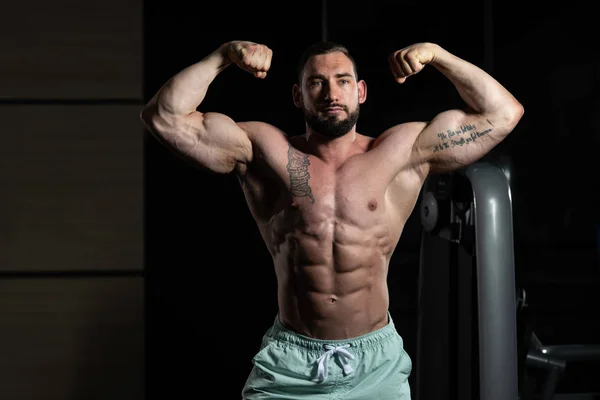 Bodybuilder in doppelter Bizeps-Pose — Stockfoto