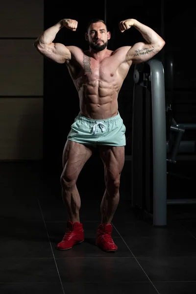 Muskulös mannen slår bakre dubbel biceps pose — Stockfoto