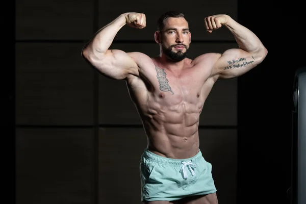 Bodybuilder presterende achterste dubbele biceps vormen — Stockfoto