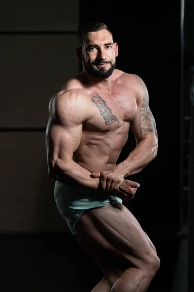 Bodybuilder presterende kant borst vormen — Stockfoto