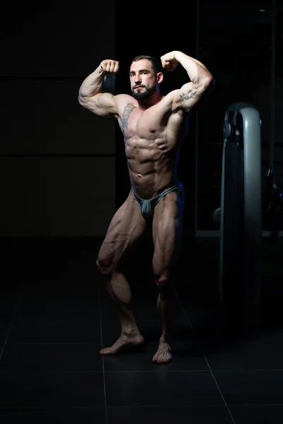 Bodybuilder effectuer arrière biceps double pose — Photo