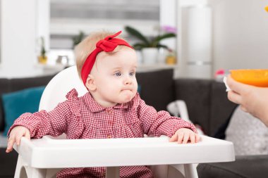 Anne, bebeğini kaşıkla besliyor anne, sevimli çocuğuna sağlıklı yiyecekler veriyor.