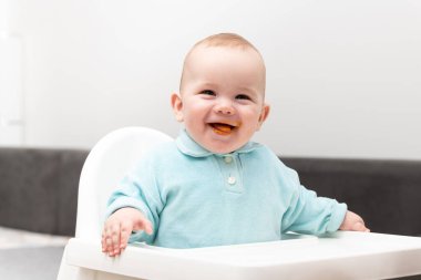 Anne, bebeğini kaşıkla besliyor. Anne, sevimli çocuğuna sağlıklı yiyecekler veriyor.