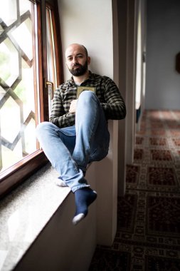 Sakallı Müslüman adam Kuran okuyor.