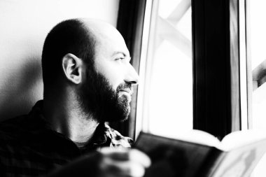 Sakallı Müslüman adam Kuran okuyor.