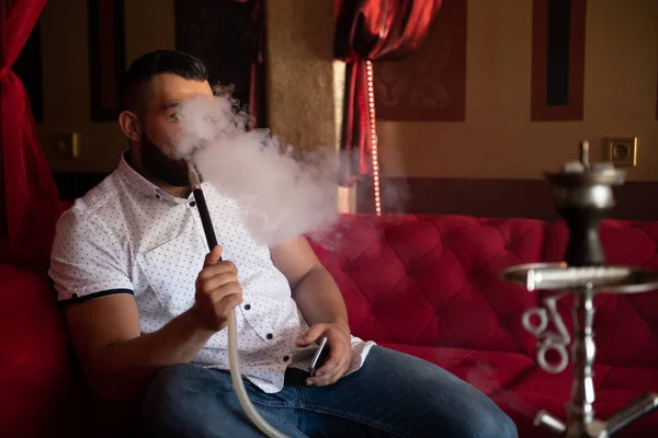 Muž Kouření Turecké Hookah Kavárně Barevnými Stěnami Pozadí Textování Telefonu — Stock fotografie