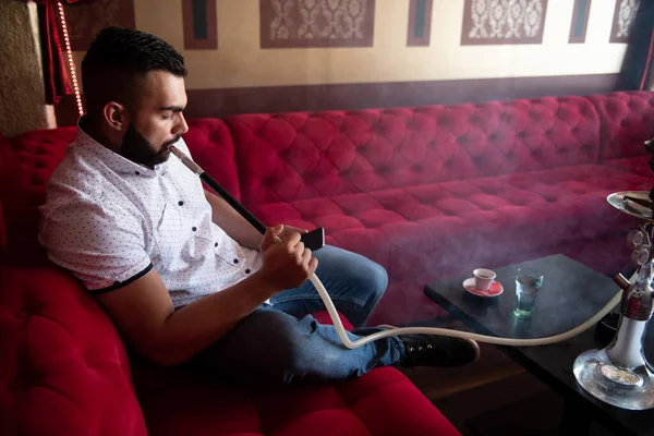 Человек Курящий Турецкий Кальян Кафе Красочными Стенами Заднем Плане Смс — стоковое фото