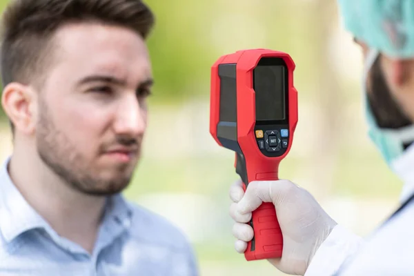 Doctor Man Gebruik Infrarood Voorhoofd Thermometer Pistool Lichaamstemperatuur Controleren Virus — Stockfoto