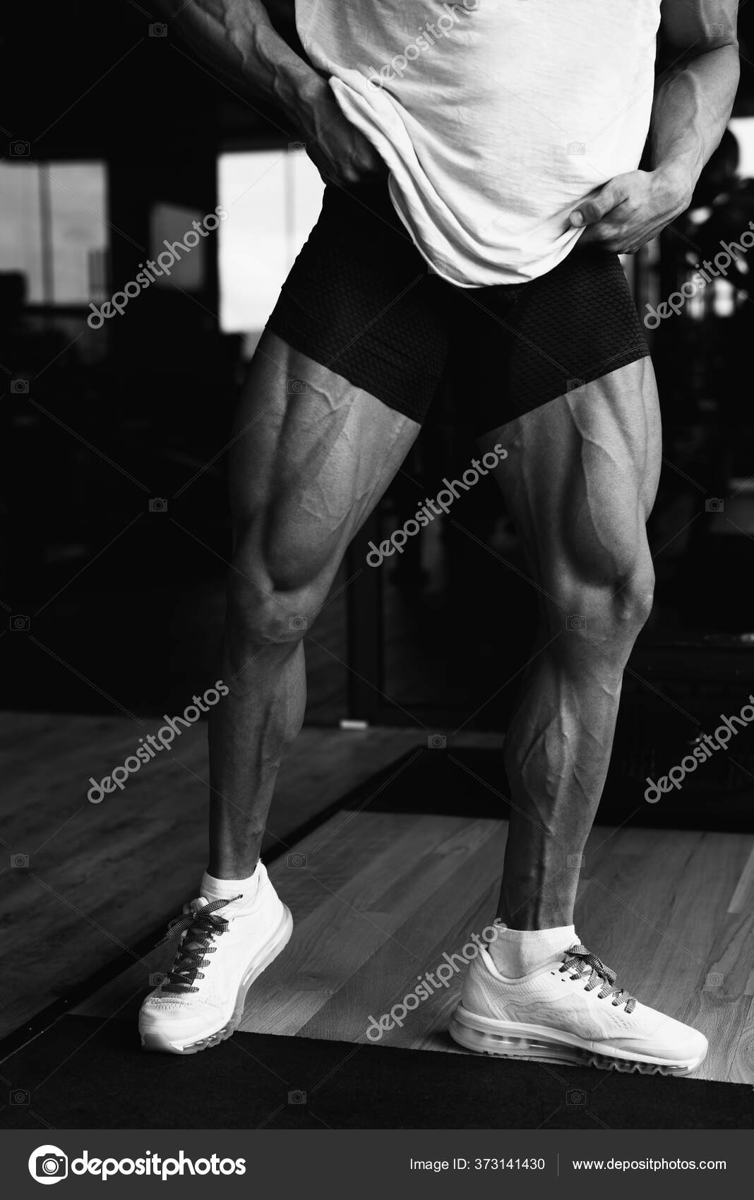Healthy Young Man Standing Strong In The Gym And Flexing Legs