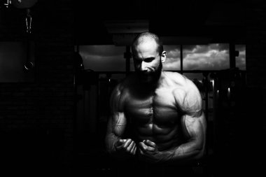 İyi eğitilmiş vücudunu gösteren genç bir adamın portresi - kaslı atletik vücut geliştirici spor sonrası vücut geliştirme modelliği pozu