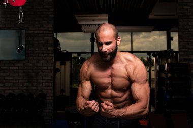 İyi eğitilmiş vücudunu gösteren genç bir adamın portresi - kaslı atletik vücut geliştirici spor sonrası vücut geliştirme modelliği pozu