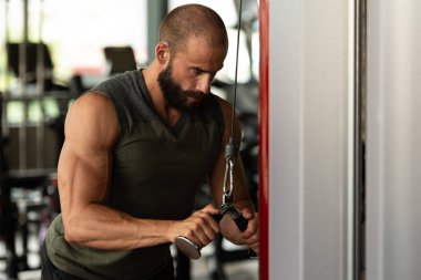 Spor salonunda kablolu Tv ile Triceps on Machine için Ağır Ağırlık Egzersizi Yapan Kas Vücut Geliştirici