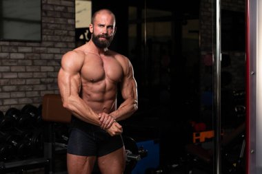 Spor Salonunda Güçlü Duran Genç Adam - Kas Atletik Vücut Geliştirici Spor Sonrası Spor Pozisyonu