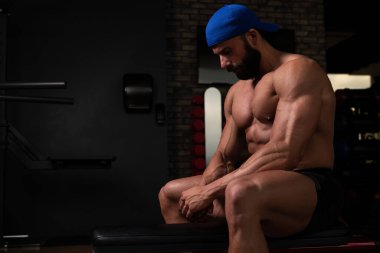 Yakışıklı ve çekici bir genç adam. Vücut kasları spor salonunda dinleniyor.