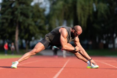Genç Sporcu Rahatlar ve Stadyumdaki Atletizm Pistinde Koşmaya Hazır