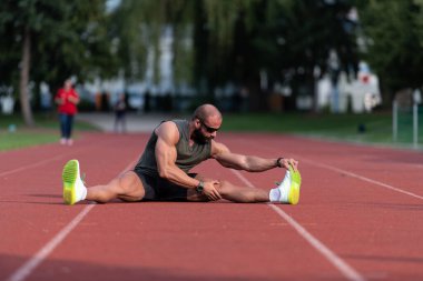 Genç Sporcu Rahatlar ve Stadyumdaki Atletizm Pistinde Koşmaya Hazır