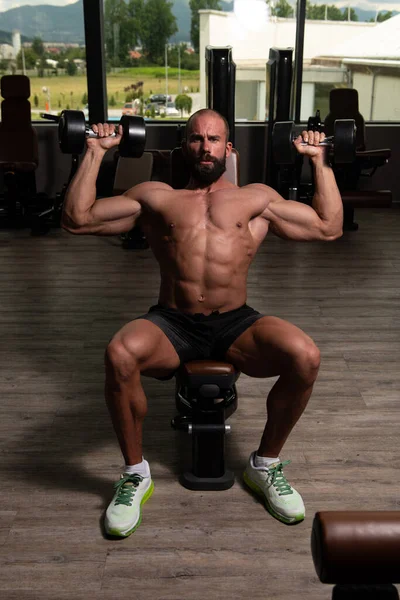 Gezonde Man Traint Schouders Een Donkere Fitnessruimte — Stockfoto
