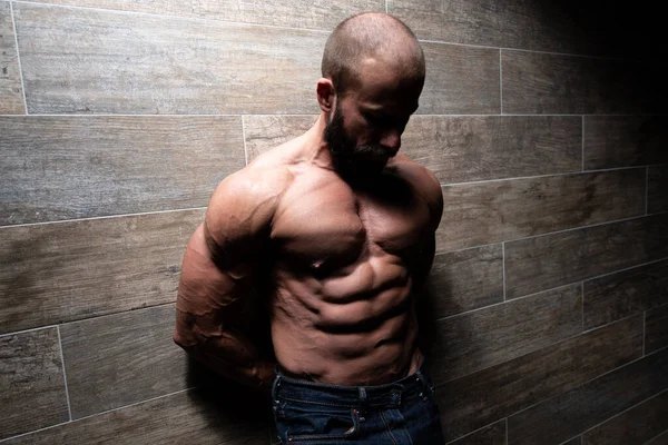 Healthy Young Man Standing Strong Standing Wall Flexing Muscles While — Φωτογραφία Αρχείου