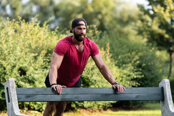 Hombre Joven Con Camiseta Roja Haciendo Flexiones Banco Madera Mientras —  Fotos de Stock