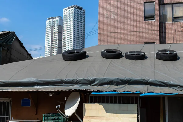 Car tires lying with on the rooftop so that the roof is not blown away by the wind. Its time to repair the roof. Leaky Roof