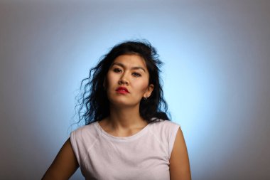 Esrarengiz ve anlayışlı bir görünümü olan Asyalı bir model. Renkli ve genç bir Asyalının stüdyo portresi. Baştan çıkarıcı bir kız bakışı..